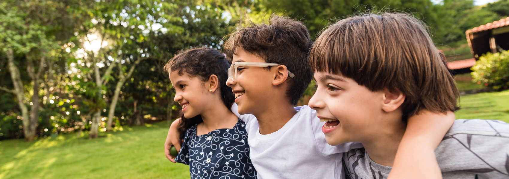 Three school-age children are playing together outside